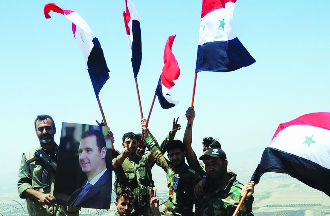 Syrian soldiers hold Syrian flags on the Tal al-Harrah in the northwestern countryside of Daraa Province, Syria, July 19, 2018. (Xinhua)