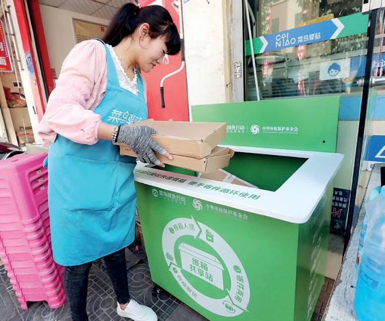 Yunnan eyaletinin Kunming şehrinde çekilen fotoğrafta bir kadın boş kutuları geri dönüşüme atıyor. (China Daily, 2018)