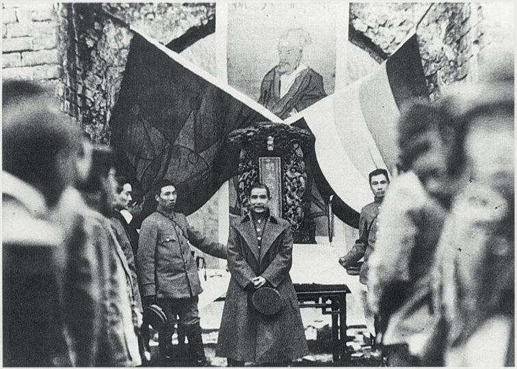 Sun Yat-sen in 1912 standing in front of the Five Races Under One Union flag and the Blue Sky with a White Sun flag (Photo: Xinhua, 2020).