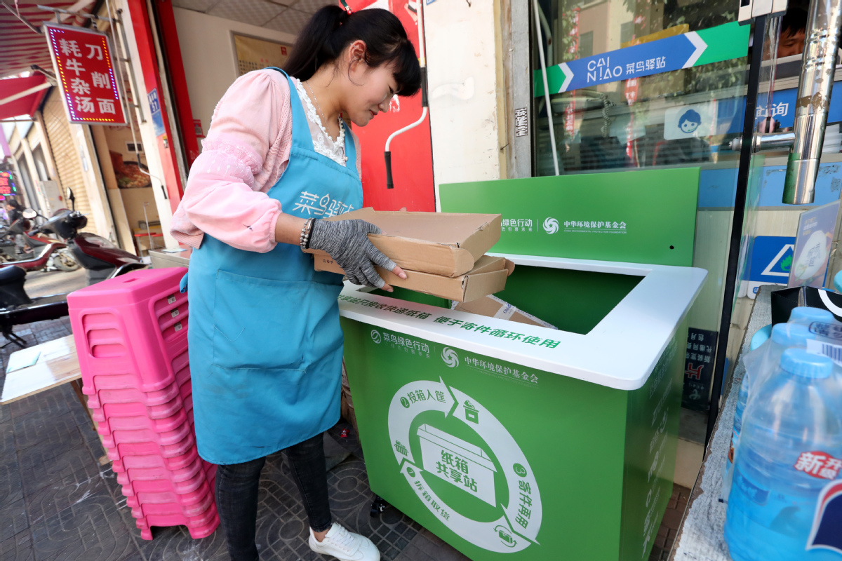 A woman drops empty delivery boxes into a community recycling bin in Kunming, Yunnan province. (China Daily, 2018)